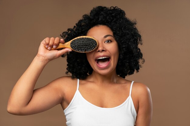 Portrait de jeune belle femme avec une brosse à cheveux