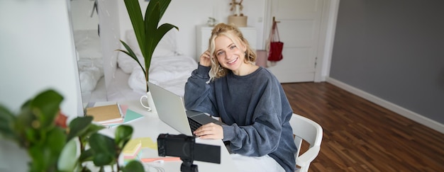 Portrait d'une jeune et belle femme influente sur les médias sociaux enregistrant un vlog de style de vie vidéo.