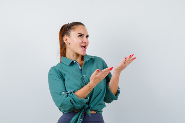 Portrait de jeune belle femme montrant l'espace de copie