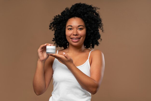 Portrait de jeune belle femme avec un produit de beauté