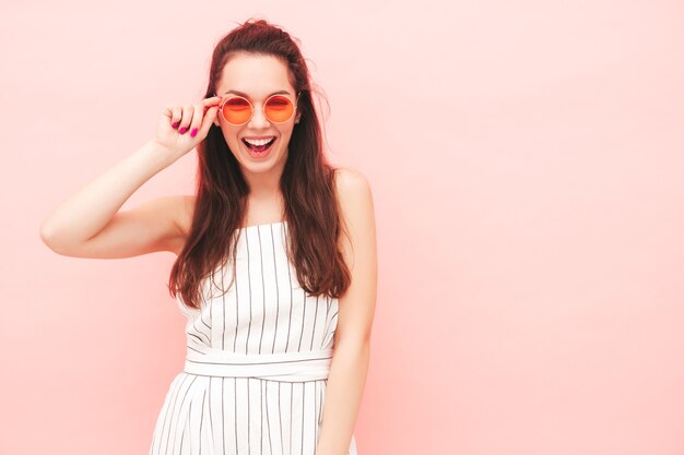 Portrait de jeune belle femme souriante dans des vêtements de salopette hipster d'été à la mode