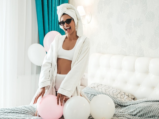 Portrait de jeune belle femme souriante en lingerie blanche et serviette sur la tête