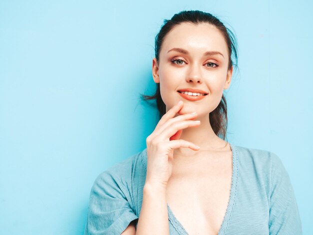 Portrait de jeune belle femme souriante en robe bleue d'été à la mode Sexy femme insouciante posant près du mur bleu en studio Modèle positif s'amusant et devenant fou Enthousiaste et heureux