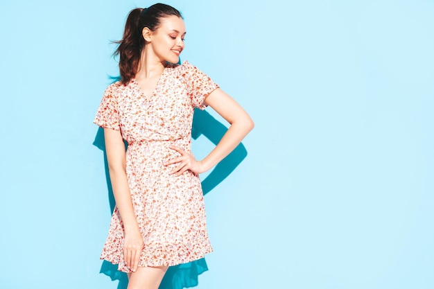 Portrait de jeune belle femme souriante en robe bleue d'été à la mode Sexy femme insouciante posant près du mur bleu en studio Modèle positif s'amusant et devenant fou Enthousiaste et heureux