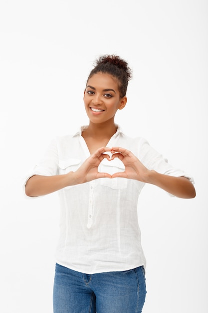 Portrait de jeune belle fille africaine sur mur blanc