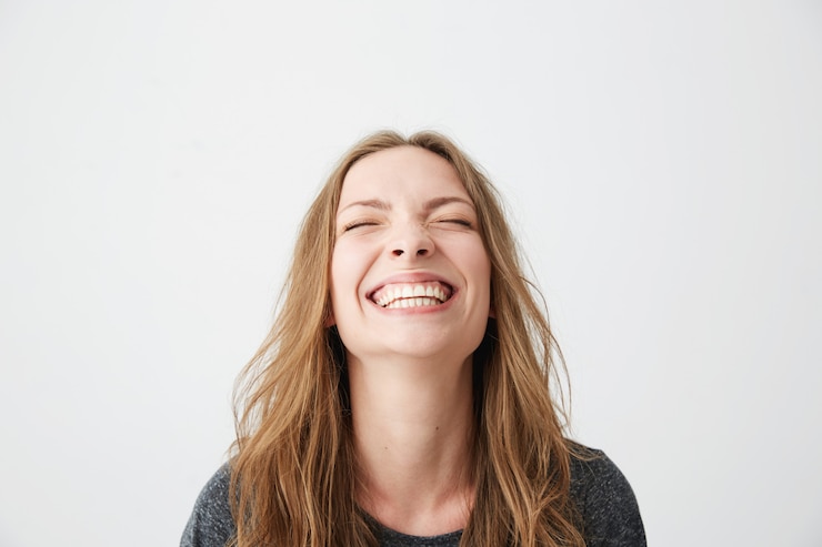 Photo gratuit portrait de jeune belle fille émotionnelle en riant les yeux fermés.
