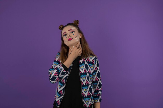 Portrait de jeune belle fille avec un maquillage fantaisie coloré sur fond violet. Photo de haute qualité