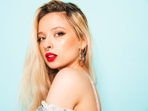 Portrait de jeune belle fille mauvaise hipster dans des vêtements jeans à la mode et boucle d'oreille dans son nez. Modèle positif s'amusant