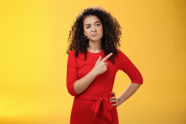 Photo gratuite portrait d'une jeune collègue aux cheveux bouclés, insouciante et ennuyée, en robe, bouleversée...