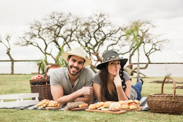 Portrait de jeune couple allongé sur une couverture au pique-nique