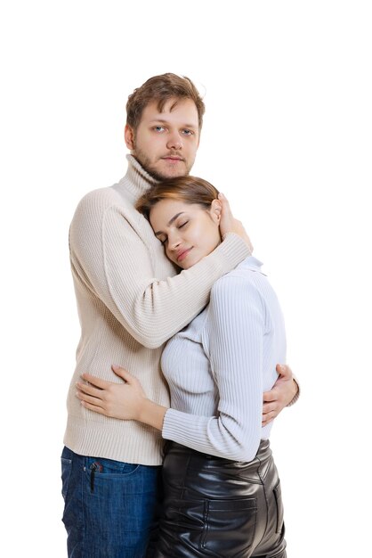 Portrait de jeune couple d'amoureux serrant tendrement les uns les autres isolés sur fond de studio blanc