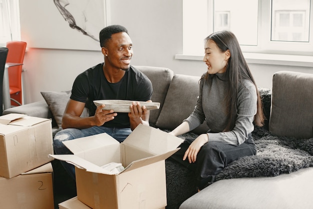 Portrait de jeune couple avec des boîtes en carton dans une nouvelle maison, concept de déménagement.