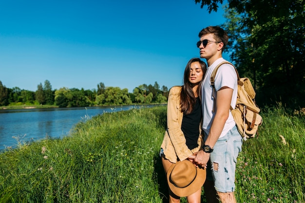 Photo gratuite portrait de jeune couple debout près du lac