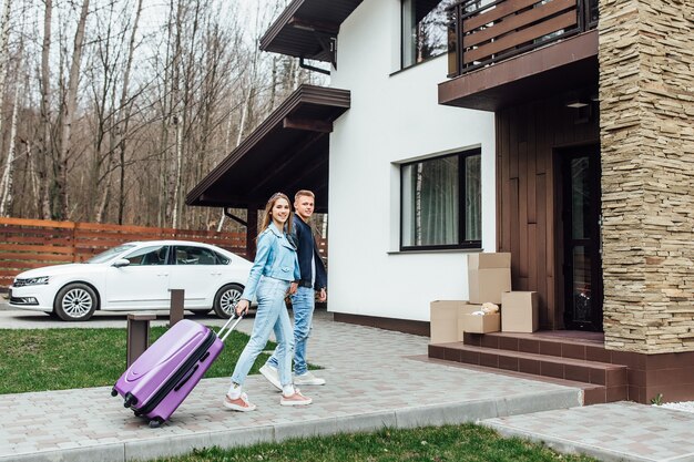 Portrait d'un jeune couple heureux s'embrassant devant leur nouvelle villa de luxe.