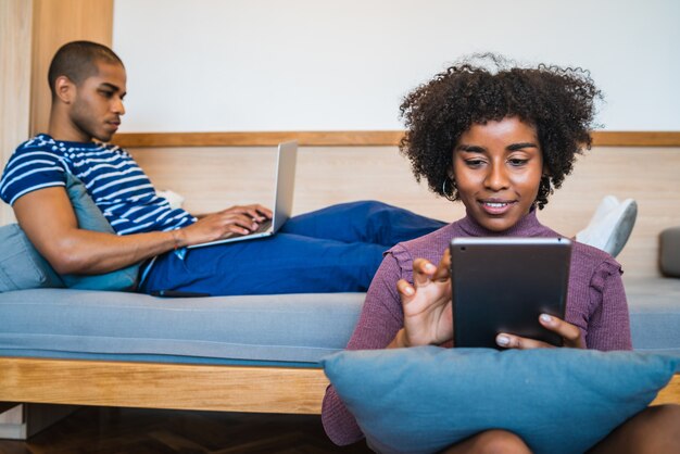 Portrait d'un jeune couple heureux se relaxant et passant le week-end ensemble sur un canapé à la maison