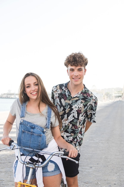 Photo gratuite portrait d'un jeune couple heureux à vélo