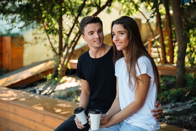 Portrait d'un jeune couple souriant, boire du café