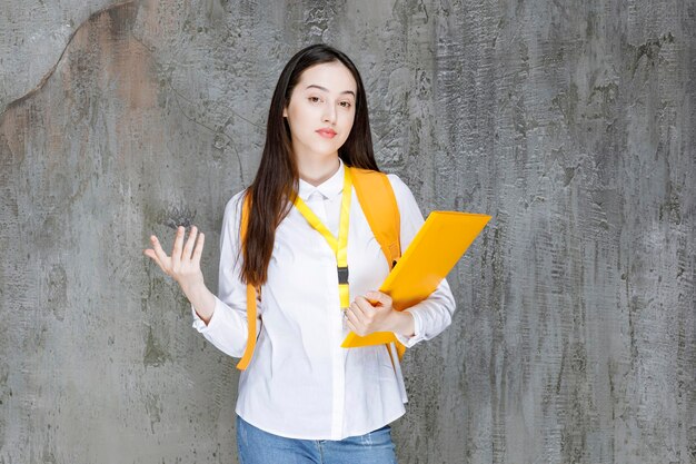 Portrait de jeune étudiant avec cahier debout sur la pierre. Photo de haute qualité