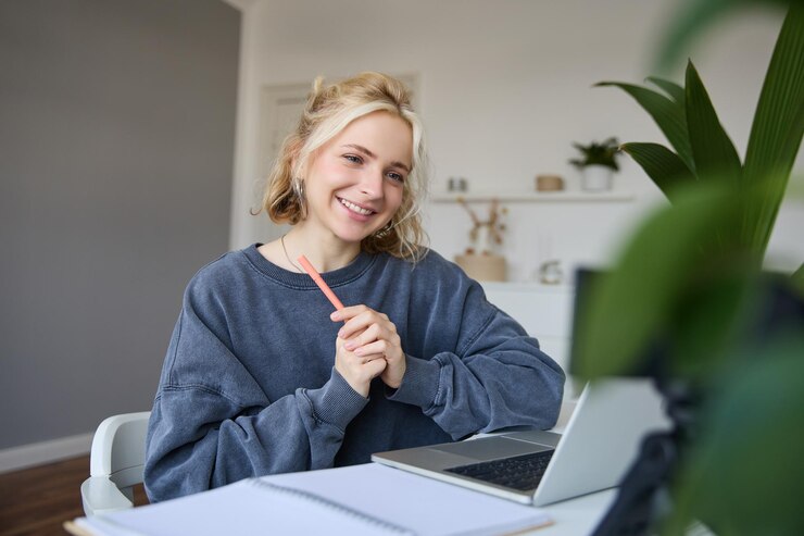 Photo gratuit portrait d'une jeune étudiante souriante qui parle à son professeur en ligne via un chat vidéo.