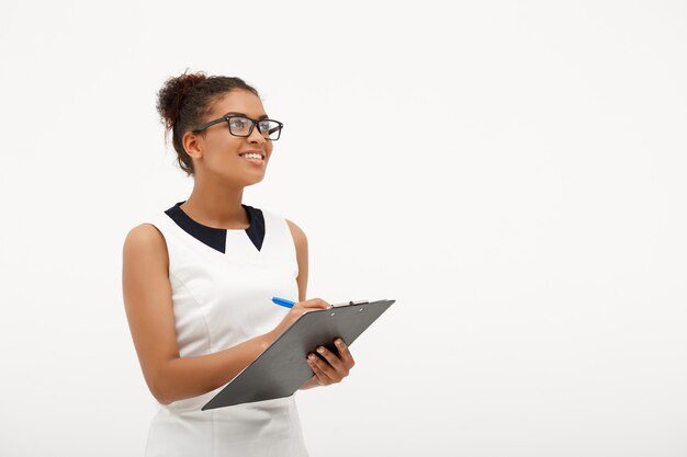 Portrait de jeune femme d'affaires africaine réussie sur blanc