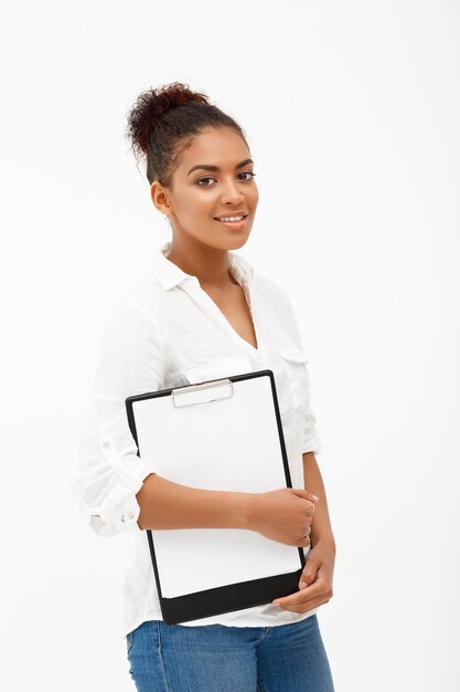 Portrait de jeune femme d'affaires africaine réussie sur mur blanc