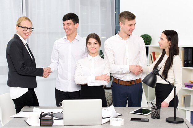 Portrait, de, a, jeune femme affaires, debout, à, professionnels, serrer main autre, à, lieu de travail