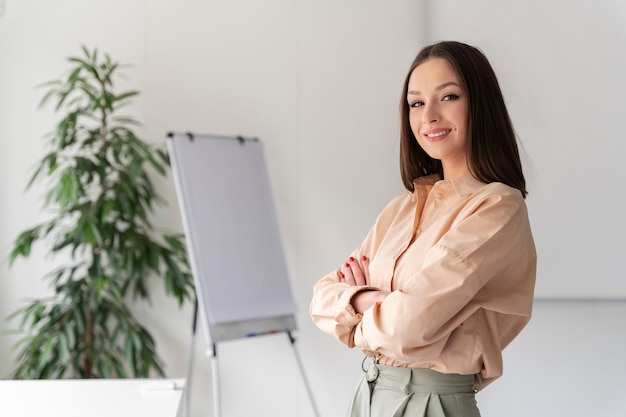 Portrait de jeune femme d'affaires posant avec les bras croisés