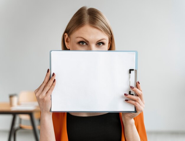 Portrait jeune femme d'affaires avec presse-papiers