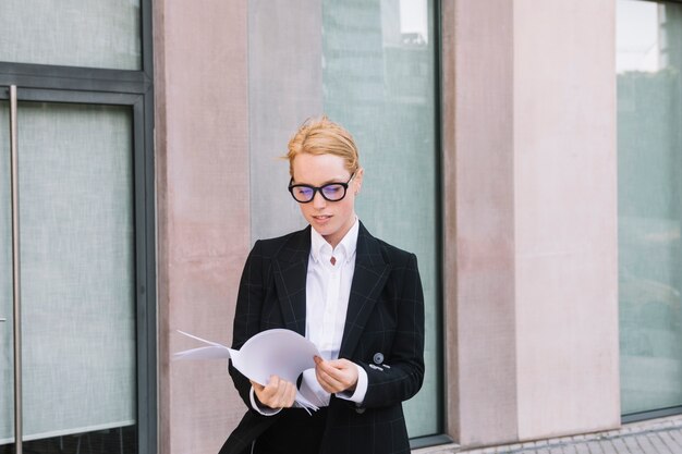 Portrait d&#39;une jeune femme d&#39;affaires vérifiant le livre blanc