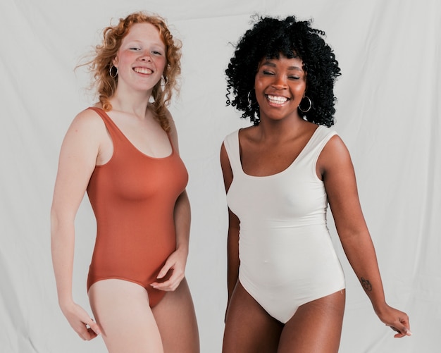 Portrait d'une jeune femme africaine et blonde qui danse sur fond gris