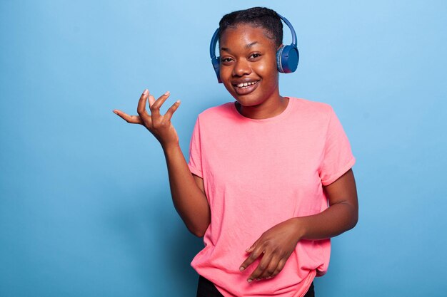 Portrait d'une jeune femme afro-américaine portant des écouteurs souriant à la caméra