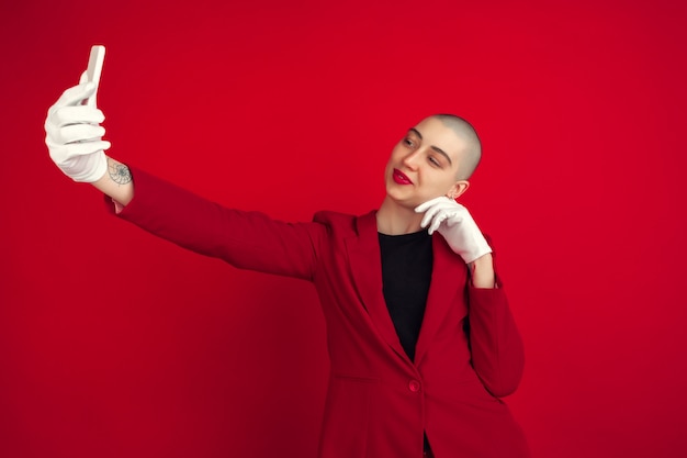 Portrait de jeune femme avec une apparence bizarre sur le mur rouge