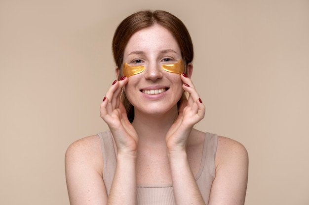 Portrait D'une Jeune Femme Appliquant Des Patchs Sous Les Yeux