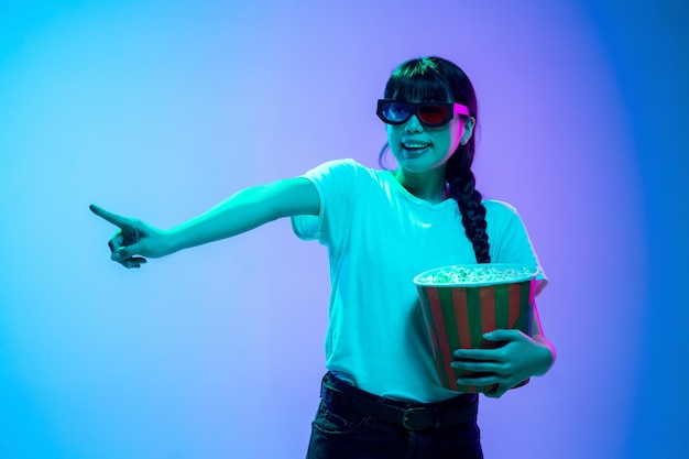 Portrait de jeune femme asiatique sur dégradé bleu-violet à la lumière néon