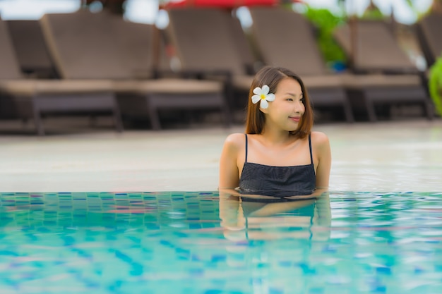 Portrait, jeune, femme asiatique, détendre, sourire, heureux, autour de, piscine extérieure, dans, hôtel, à, mer, vue océan