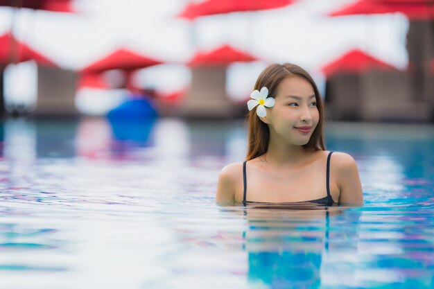 Portrait, jeune, femme asiatique, détendre, sourire, heureux, autour de, piscine extérieure, dans, hôtel, à, mer, vue océan