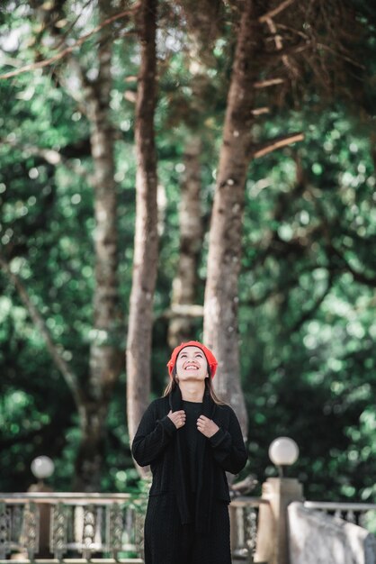 Portrait d'une jeune femme asiatique heureuse en costume d'hiver dans la forêt avec espace de copie Concept de vacances et de voyage