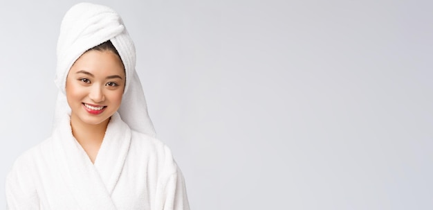 Portrait d'une jeune femme asiatique heureuse en peignoirIsolé sur fond blanc