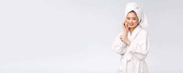 Portrait d'une jeune femme asiatique heureuse en peignoirIsolé sur fond blanc