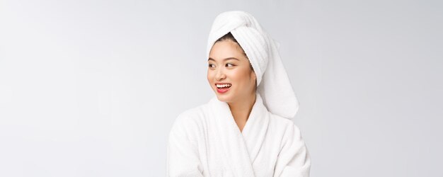 Portrait d'une jeune femme asiatique heureuse en peignoirIsolé sur fond blanc