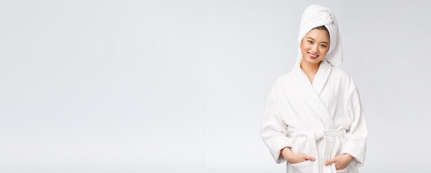 Portrait d'une jeune femme asiatique heureuse en peignoirIsolé sur fond blanc