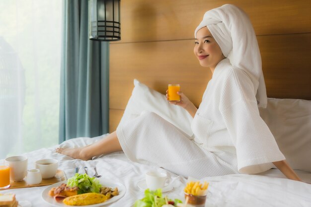 Portrait jeune femme asiatique sur lit avec petit déjeuner dans la chambre