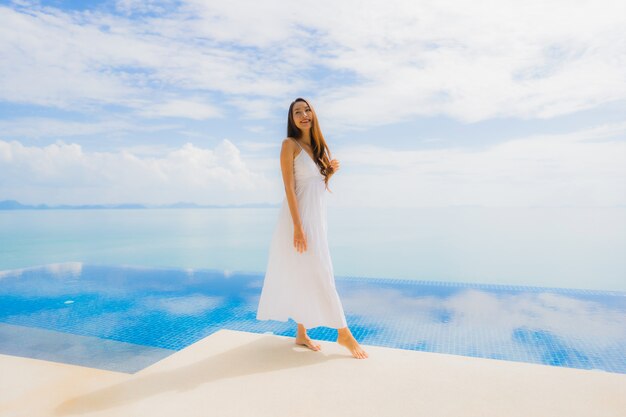 Portrait de jeune femme asiatique se détendre sourire heureux autour de la piscine dans l'hôtel et resort