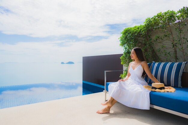 Portrait de jeune femme asiatique se détendre sourire heureux autour de la piscine dans l'hôtel et resort