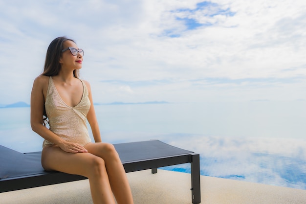 Portrait de jeune femme asiatique se détendre sourire heureux autour de la piscine dans l'hôtel et resort