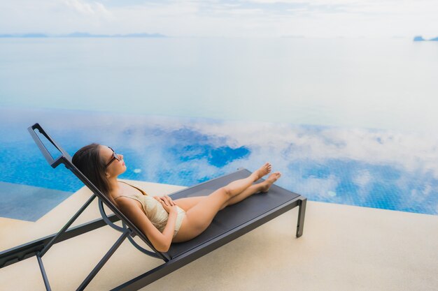 Portrait de jeune femme asiatique se détendre sourire heureux autour de la piscine dans l'hôtel et resort