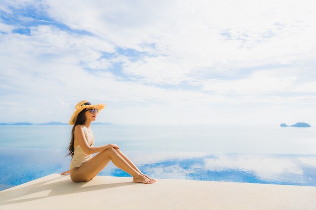 Portrait de jeune femme asiatique se détendre sourire heureux autour de la piscine dans l'hôtel et resort