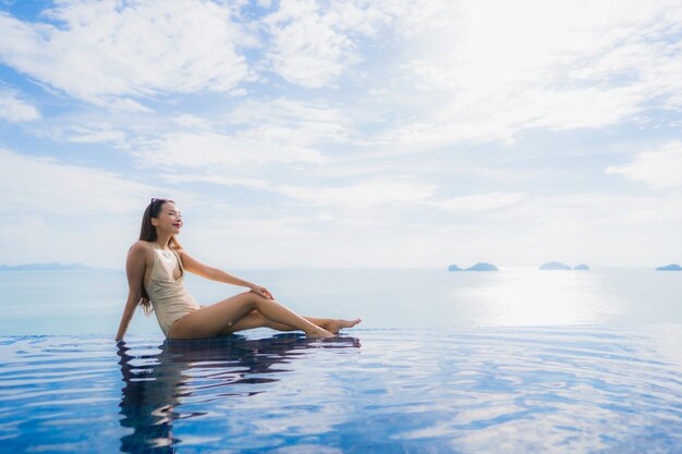 Portrait de jeune femme asiatique se détendre sourire heureux autour de la piscine dans l'hôtel et resort