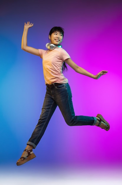 Portrait de jeune femme asiatique sur studio dégradé en néon