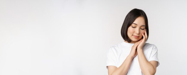 Portrait d'une jeune femme asiatique tendre et féminine regardant doucement le concept de visage de peau